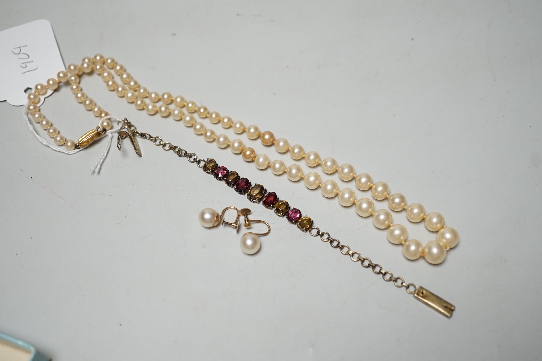 A gilt metal and coloured paste set bracelet, a pair of 9ct and cultured pearl set ear clips and a simulated pearl necklace, with 9ct clasp.